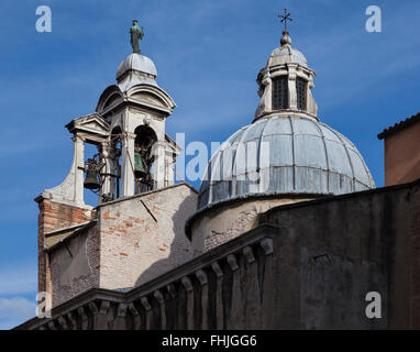 Sonnenbeschienenen kunstvollen Glockenturm mit dem komplexen Uhrwerk sichtbar und Kuppel der Chiesa di San Giacomo di Rialto, Venedig, Italien unter einem blauen Himmel Stockfoto
