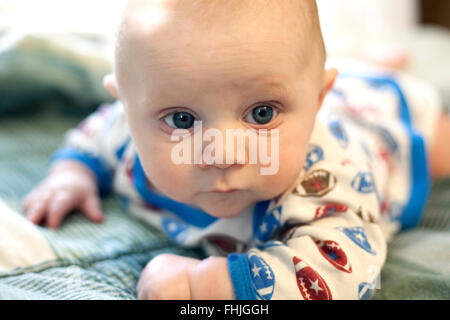 Baby Boy auf einem Bett Stockfoto