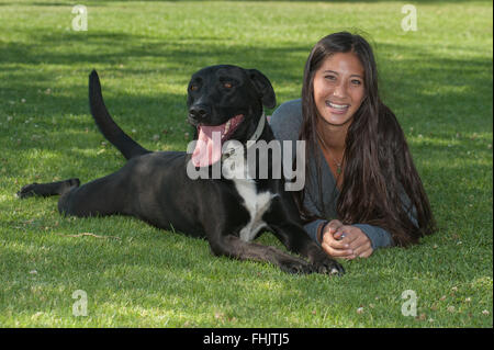 Mädchen liegend mit ihrem Hund im park Stockfoto