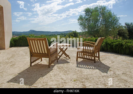 Mallorca, Mallorca, Balearen, Spanien, Europa: zwei Stühlen mit Blick über die mallorquinische Landschaft mit grünen Wiesen und Olivenbäumen. Stockfoto