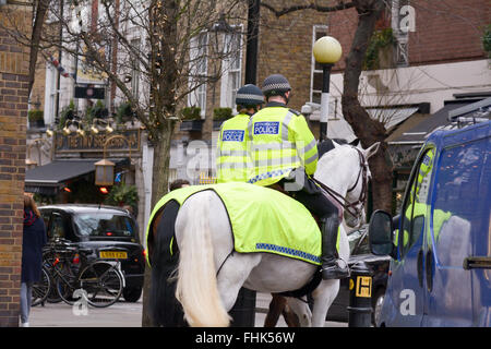 Zwei Metropolitan Polizisten patrouillieren in den Straßen auf dem Pferderücken in London, England Stockfoto