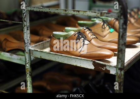 Bücherregal in der Studio-Schuster an die eingestellte Paare von eleganten Herrenschuhe. Stockfoto