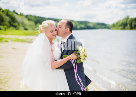 Braut und Bräutigam zu Fuß am Fluss Stockfoto