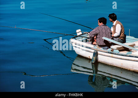 Zwei türkische Fischer Fischen vom Ruderboot im Hafen von Bodrum, Bodrum, Türkei Stockfoto