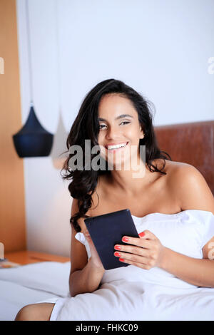 Hispanic Frau mit ihrem Handheld-Gerät in ihrem Hotelzimmer Stockfoto