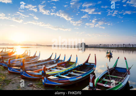 Mandalay, Amarapura, Taungthaman Lake, Burmesische Boote auf dem See mit U Bein Teakholz Brücke im Hintergrund, Sonnenaufgang, keine Menschen, ruhige Szene Stockfoto