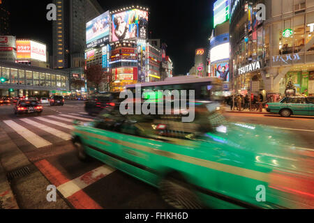 Neon-Leuchten durch die Welten verkehrsreichsten Kreuzung in Shibuya, Tokio. Stockfoto