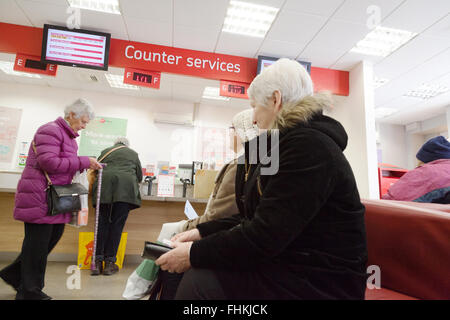 Menschen warten in der Warteschlangen-System für Zähler Dienstleistungen, Cambridge Post Office, Cambridge England UK Stockfoto