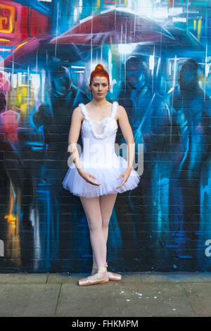 Ballerina in einem städtischen Umfeld. Vor Graffiti von Dan Kitchener (Dank) an Custard Factory, Birmingham, UK Stockfoto