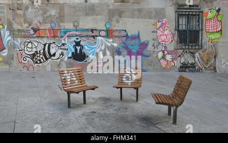 Der malerische Ort einsam Stühle mit einem Hintergrund von Graffiti auf den Aufbau in den Straßen der Altstadt. Stockfoto