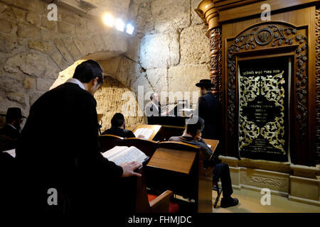 Orthodoxe religiöse Juden beten in einer Synagoge an den unterirdischen Tunneln der Westmauer, die aus künstlichen Tunneln bestehen, die gegraben wurden, um die Westmauer und damit verbundene Antiquitäten zu erforschen. Der Großteil des Tunnels ist eine Fortsetzung der offenen Westmauer und befindet sich unter den Gebäuden des muslimischen Viertels der Altstadt von Jerusalem. Israel Stockfoto