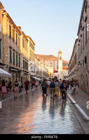 Touristen-Spaziergang entlang der marmornen Straßen der Altstadt von Dubrovnik in Kroatien bei Sonnenuntergang Stockfoto