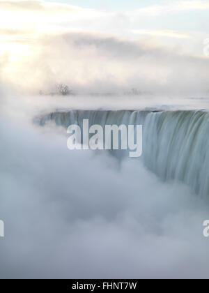 Niagara-Fälle abgedeckt, in dicken weißen Nebel, kanadischen Horseshoe, wunderschönen Sonnenaufgang Landschaft in weichen hellen Pastelltönen, Winter Stockfoto