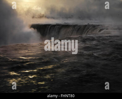 Niagara Falls in Nebel, dramatische geheimnisvolle dunkle Sonnenaufgang Landschaft, malerische Winter abgedeckt. Niagara Falls, Ontario, Ca Stockfoto