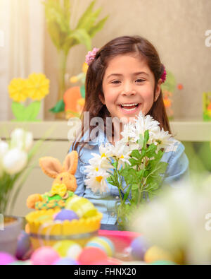 Porträt von fröhlich lächelnde Mädchen sitzen im Kinderzimmer mit schönen Daisy blumeblumenstrauß, das Osterfest Stockfoto
