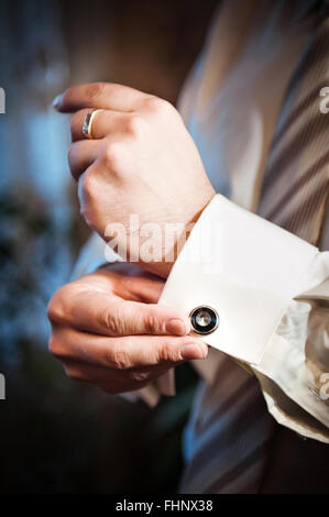 Man legt Manschettenknöpfe auf weißen t-Shirts Stockfoto