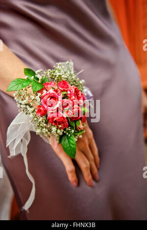 Brautjungfer in Luxus Brautkleid trägt, zarte Boutonniere mit Rosen Stockfoto