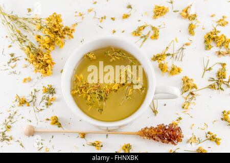 St Johns Johanniskraut Tee und umgeben von getrockneten Kantarion Pflanzen Stockfoto