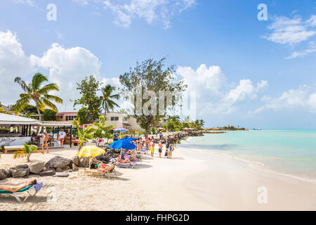 Dickenson Bay im Norden Antigua mit Sonnenschirmen, weißer Sand, blauer Himmel und das türkisblaue Meer an einem sonnigen Tag, Antigua und Barbuda Stockfoto