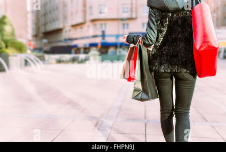 Rückansicht des jungen Frau Einkaufstaschen tragen Stockfoto