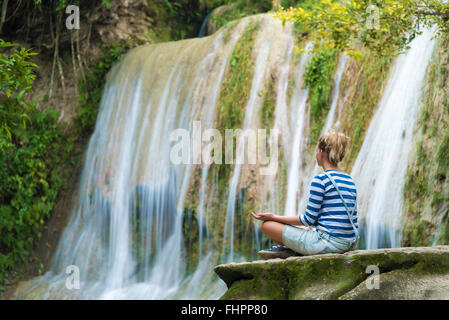 Attraktive Youn Frau während der Meditation in der Nähe des Wasserfalls, Java, Indonesien Stockfoto