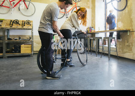 Verkäufer Beratung Client in ein maßgeschneidertes Fahrrad speichern Stockfoto