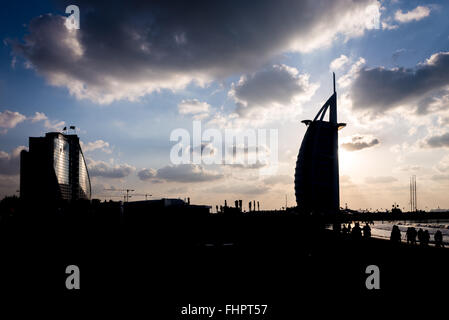 Dubai, Vereinigte Arabische Emirate - 2. Dezember 2014: der Blick auf das Burj Al Arab Silhouette und Touristen in der Dämmerung, vom Jumeirah Beach entfernt. BU Stockfoto