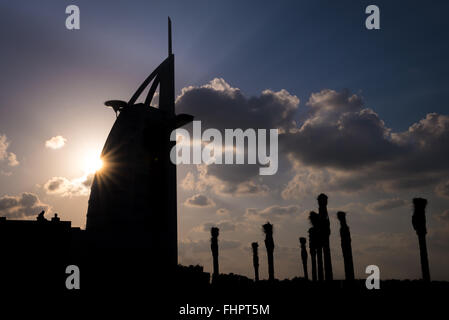 Dubai, Vereinigte Arabische Emirate - 2. Dezember 2014: Blick auf den Burj Al Arab Silhouette und Touristen in der Abenddämmerung. Blick vom Strand von Jumeirah. Stockfoto