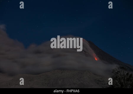 Sumatra, Indonesien. 25. Februar 2016. (Foto aufgenommen am 25. Februar 2016 zeigt Lava und Asche stieg von Mount Sinabung während einer Eruption in Karo, Nord-Sumatra, Indonesien. Behörden haben wiederholt aufgefordert Anwohner weiterhin geduldig im Umgang mit den Auswirkungen der Sinabung Eruptionen, die einige Experten vorausgesagt haben um weitere fünf Jahre fortsetzen wird. (Xinhua/YT Haryanto) Bildnachweis: Xinhua/Alamy Live-Nachrichten Stockfoto