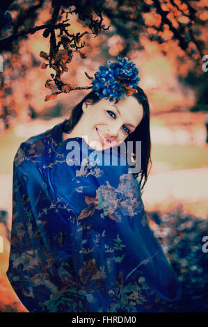 dunkle Haare junge lächelnde Frau posiert im park Stockfoto