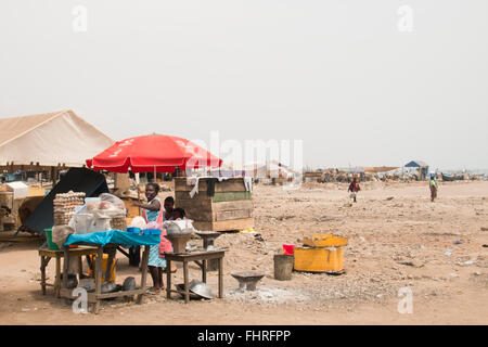 ACCRA, GHANA - Januar 2016: Garküche umgeben von Menschen am Strand in Accra, Ghana am Golf von Guinea Stockfoto