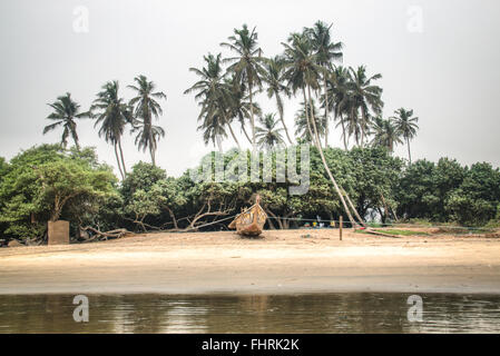 Boot, umgeben von Palmen am Strand von Krokobite in Accra, Ghana Stockfoto