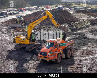 Muldenkipper verladen von einem Bagger auf der Baustelle Stockfoto