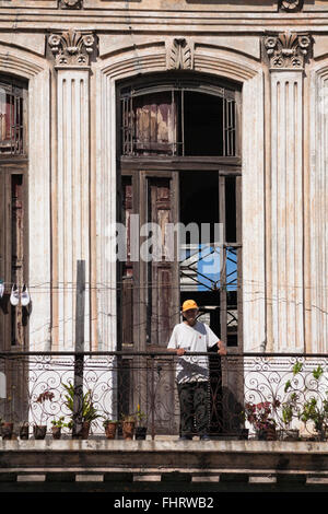 Alltag in Kuba - kubanische senior Mann stützte sich auf Balkongeländer in Havanna, Kuba, Westindische Inseln, Karibik, Mittelamerika Stockfoto