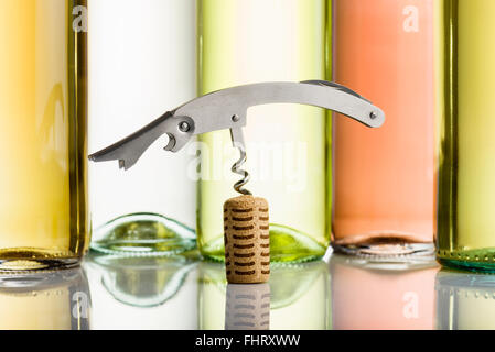 Korkenzieher auf Kork mit Weinflaschen auf Hintergrund eingefügt Stockfoto