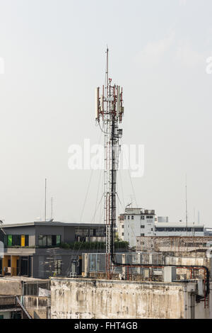 Fernmeldeturm mit mehreren Antennen und Daten Sendern mit wunderschönen Stadt im Hintergrund und breiten Berg sind Stockfoto