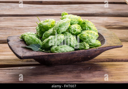 Hüpfen Sie Zapfen in die Holztablett auf dem Holztisch. Stockfoto