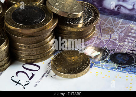 Ein Makro-Bild von Münzen und Banknoten des britischen Reiches. Insbesondere zwei Pfund-Münzen, ein Pfund Münzen und 20 Pfund-Noten. Stockfoto