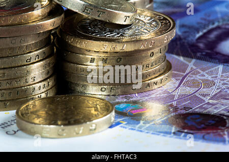 Ein Makro-Bild von Münzen und Banknoten des britischen Reiches. Insbesondere zwei Pfund-Münzen, ein Pfund Münzen und 20 Pfund-Noten. Stockfoto