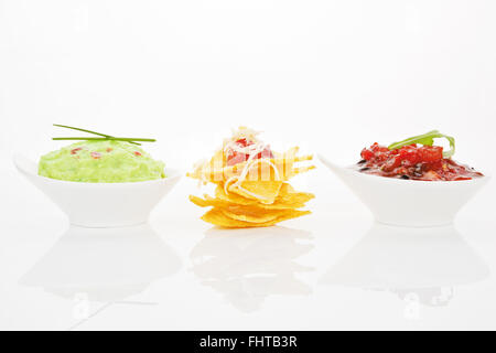 Nachos mit verschiedenen Dips isoliert. Stockfoto