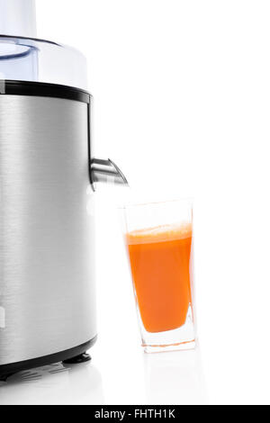 Frischer Karottensaft mit Entsafter isoliert. Stockfoto