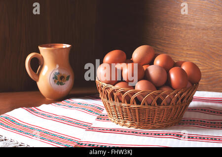 Ein Korb voller Frische Hühnereier aus einer privaten Farm. Eiern auf hölzernen Hintergrund und weißen Handtuch. Food-Fotografie Stockfoto