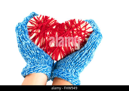 Der Frau oder des Mädchens Hände in blaue Handschuhe halten eine gewebte rotes Herz Valentinstag auf weißem Hintergrund isoliert Stockfoto