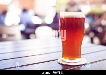 Pint gestaltete Ale auf Holztisch im Biergarten Stockfoto