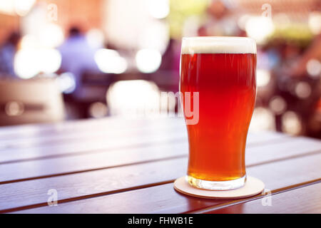 Pint gestaltete Ale auf Holztisch im Biergarten Stockfoto