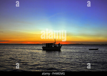 Landschaft mit Sonnenuntergang und Fischerboot am Strand Porto da Barra Stockfoto