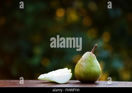 Köstliche Bio Birne auf rustikalen Holz mit schönen Bokeh im Hintergrund. Geringe Schärfentiefe Stockfoto