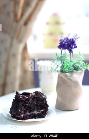 Köstlichen Brownie auf einer Platte in einem Café-Interieur. Flache Schärfentiefe und schöne cremige bokeh Stockfoto