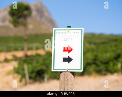 Melden Sie sich als Wegweiser für rote und schwarze Trails im Helderberg Nature Reserve in Südafrika. Weinberge im Hintergrund. Stockfoto