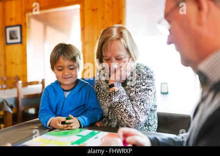 Großeltern ihre Enkel Ludo zu spielen Stockfoto